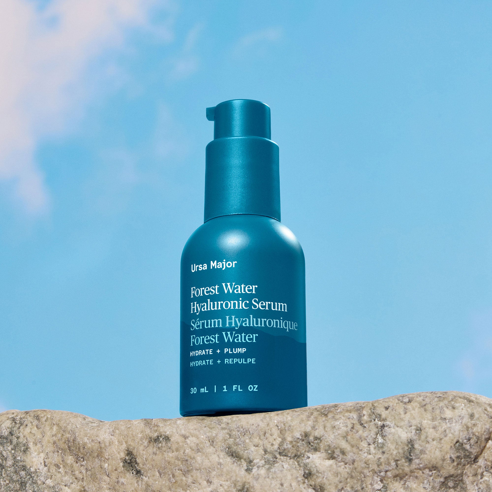 Blue serum bottle labeled 'Ursa Major' on a rock with a blue sky background