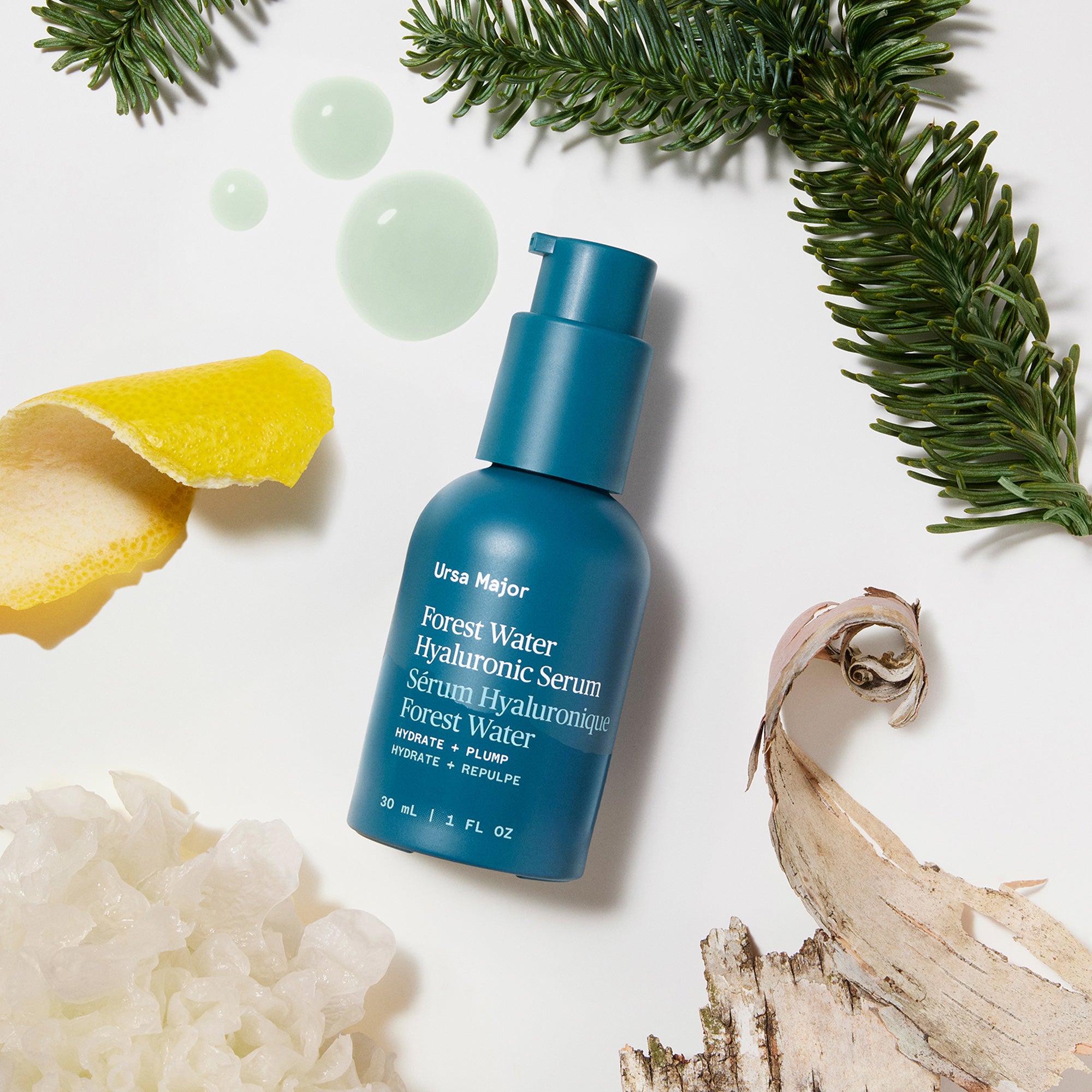 Blue skincare serum bottle with natural elements on a light background