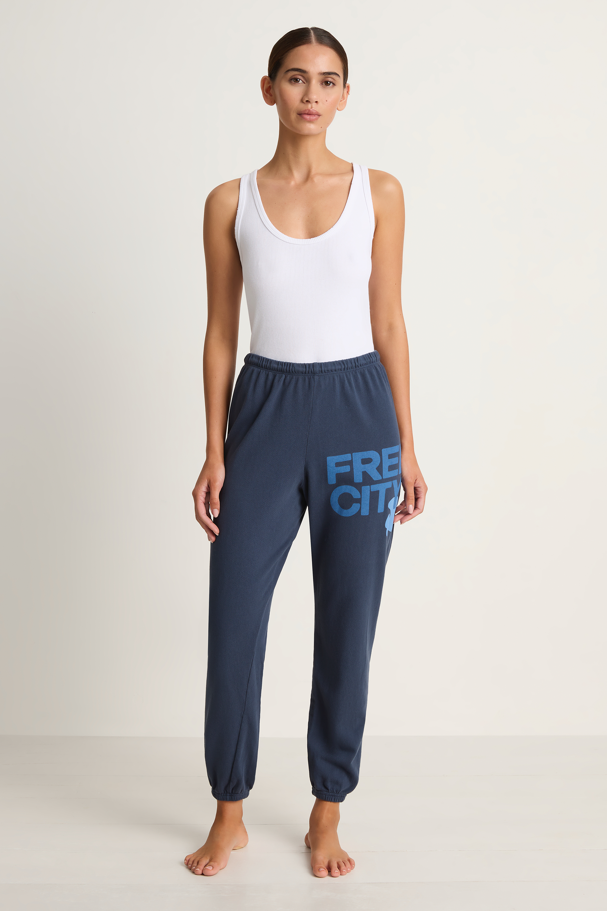 Woman wearing navy sweatpants with 'FREECITY' text on a white background