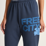 Navy sweatpants with 'Free City' text and logo on a light background