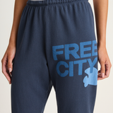 Navy sweatpants with 'Free City' text and logo on a light background