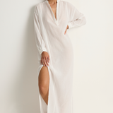 Woman wearing a white dress with a slit on a white background