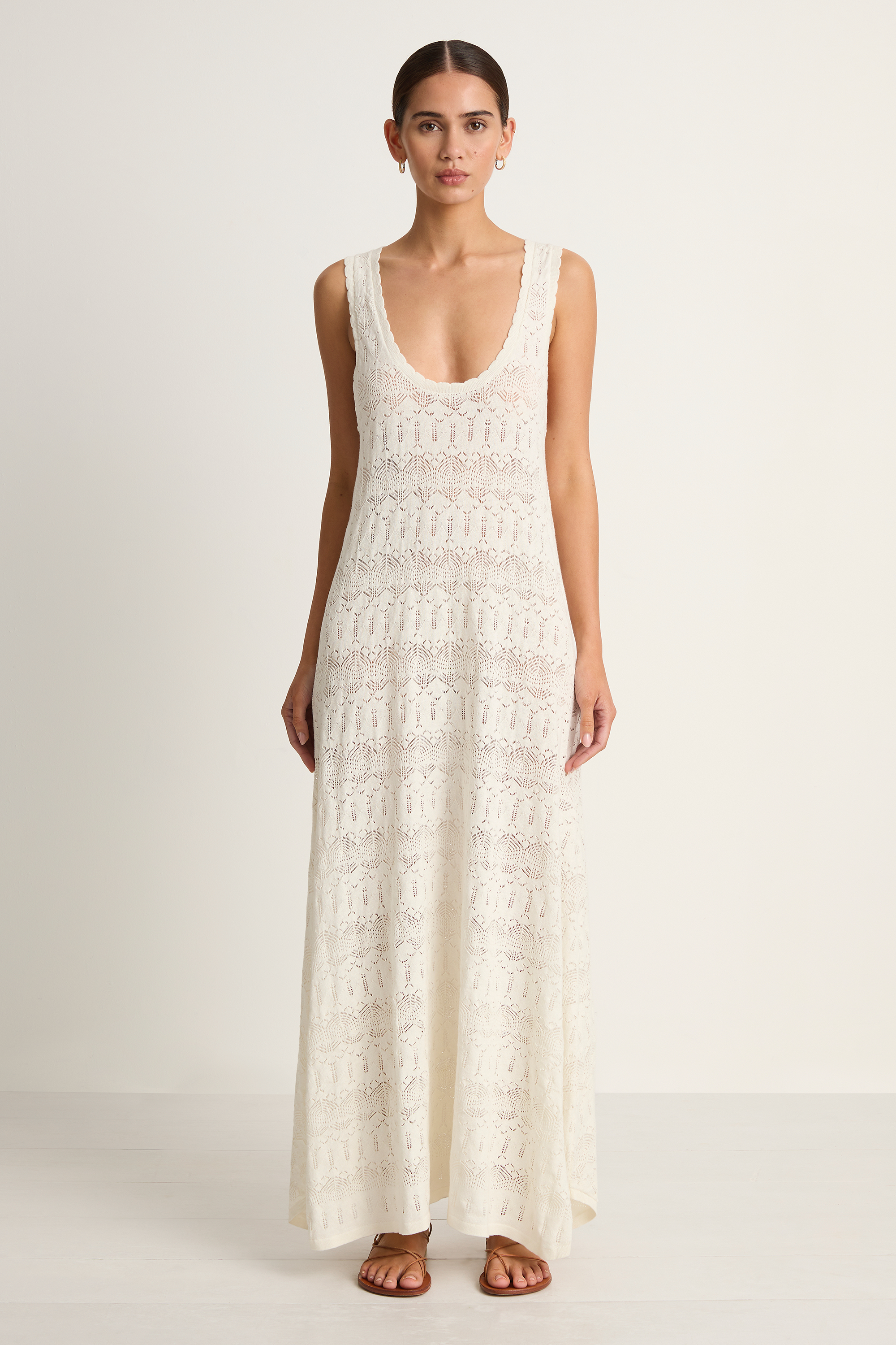 Woman wearing a white lace dress on a plain background