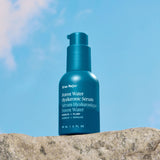 Blue serum bottle labeled 'Ursa Major' on a rock with a blue sky background