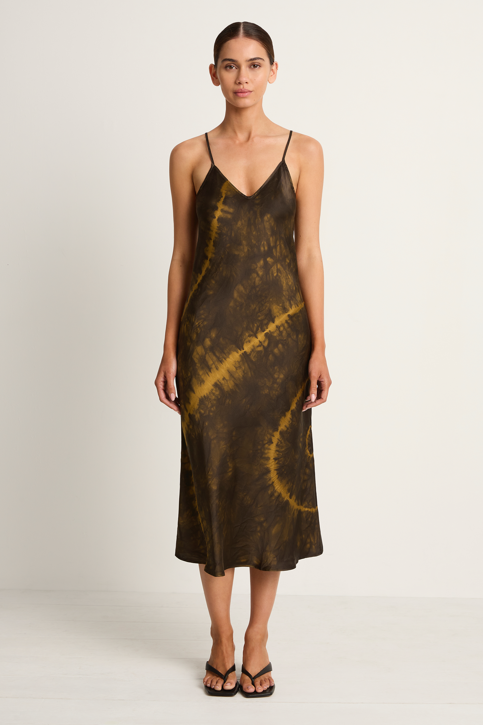 Woman wearing a tie-dye slip dress on a white background