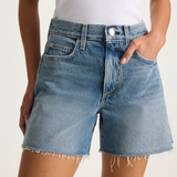 Blue denim shorts worn by a person on a white background
