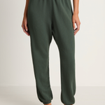 Person wearing green lounge pants on a white background