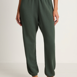 Person wearing green lounge pants on a white background