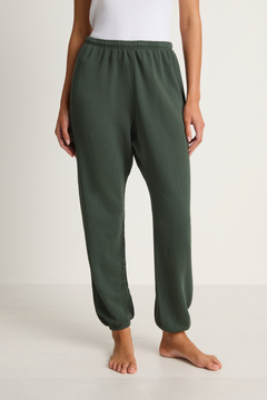 Person wearing green lounge pants on a white background