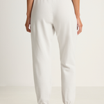 White sweatpants worn by a person on a white background