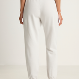 White sweatpants worn by a person on a white background