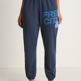 Navy sweatpants with 'FREECITY' logo worn by a person on a white background