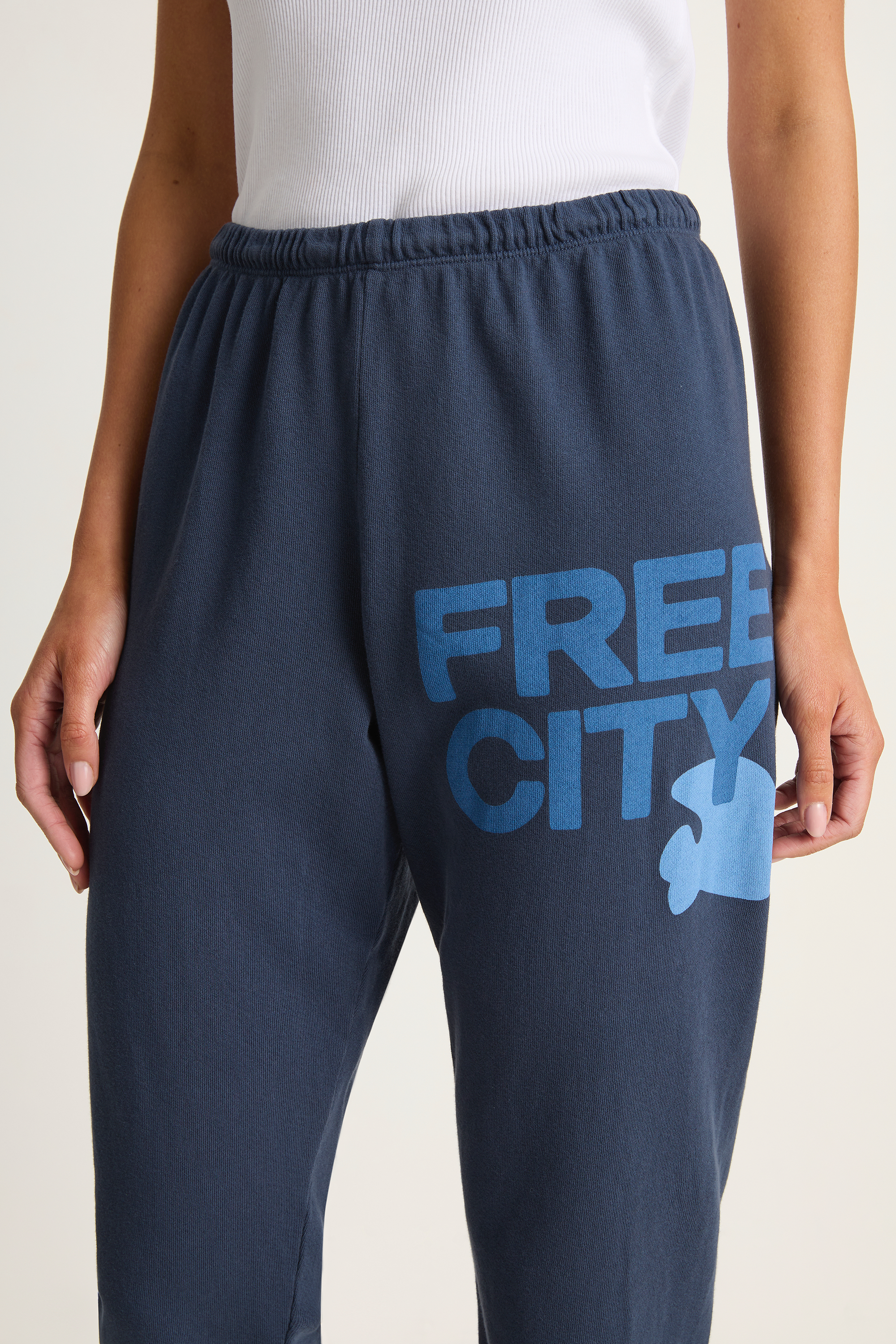 Navy sweatpants with 'Free City' text and logo on a light background