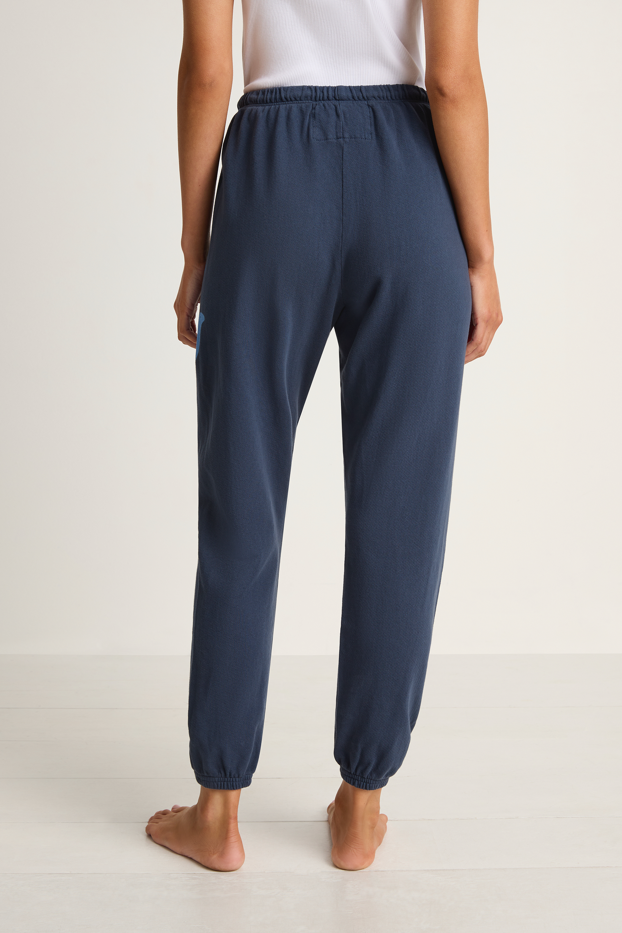 Person wearing navy blue pants on a white background