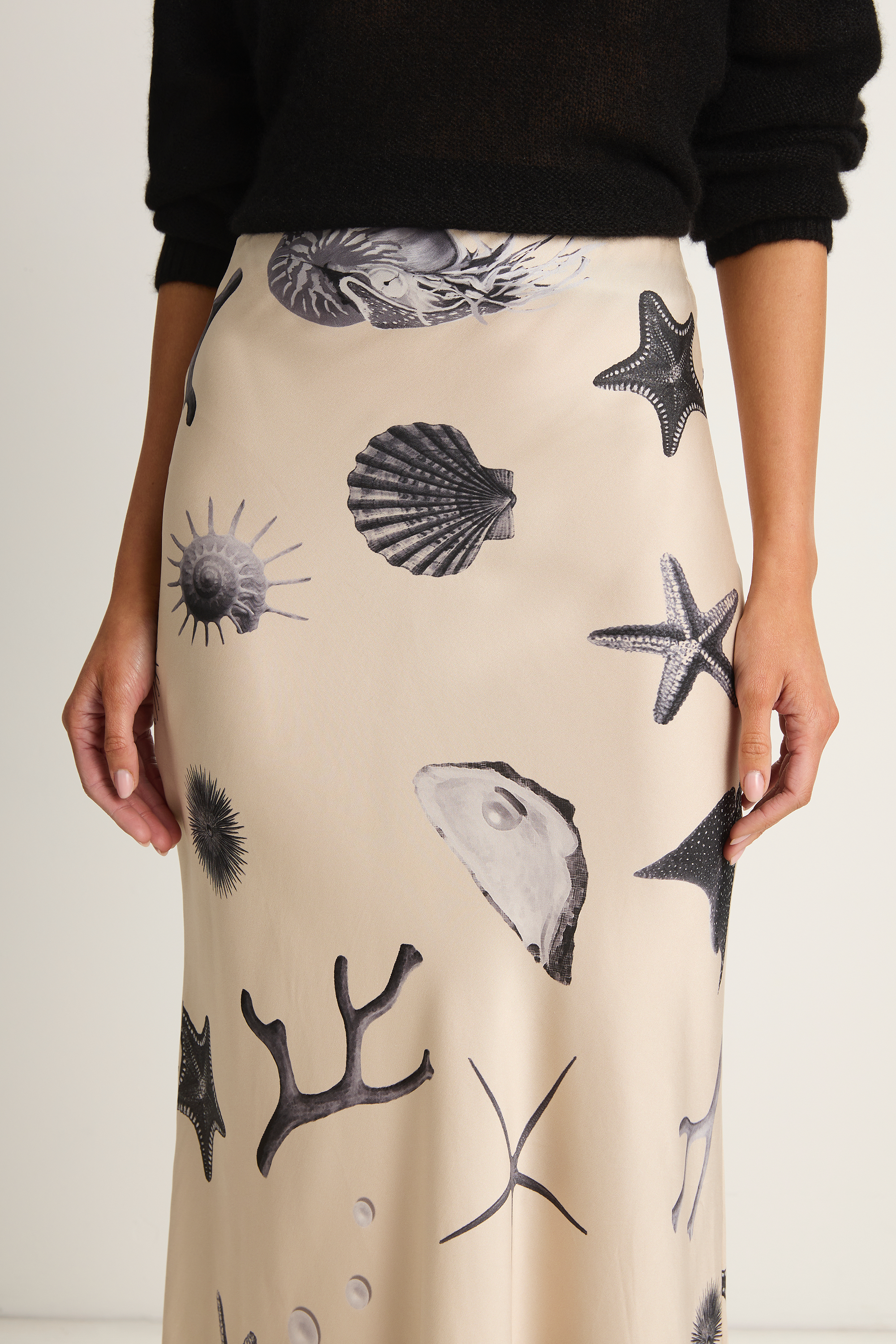 Beige skirt with black sea-themed pattern worn by a person against a white background