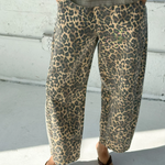Person wearing leopard print pants and a green top on a light-colored floor.