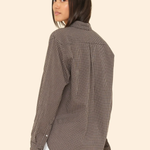 Woman wearing a checkered shirt on a beige background