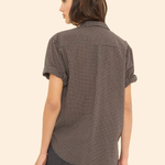 Woman wearing a checkered shirt on a beige background
