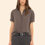 Woman wearing a checkered shirt and dark pants on a beige background