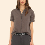Woman wearing a checkered shirt and dark pants on a beige background